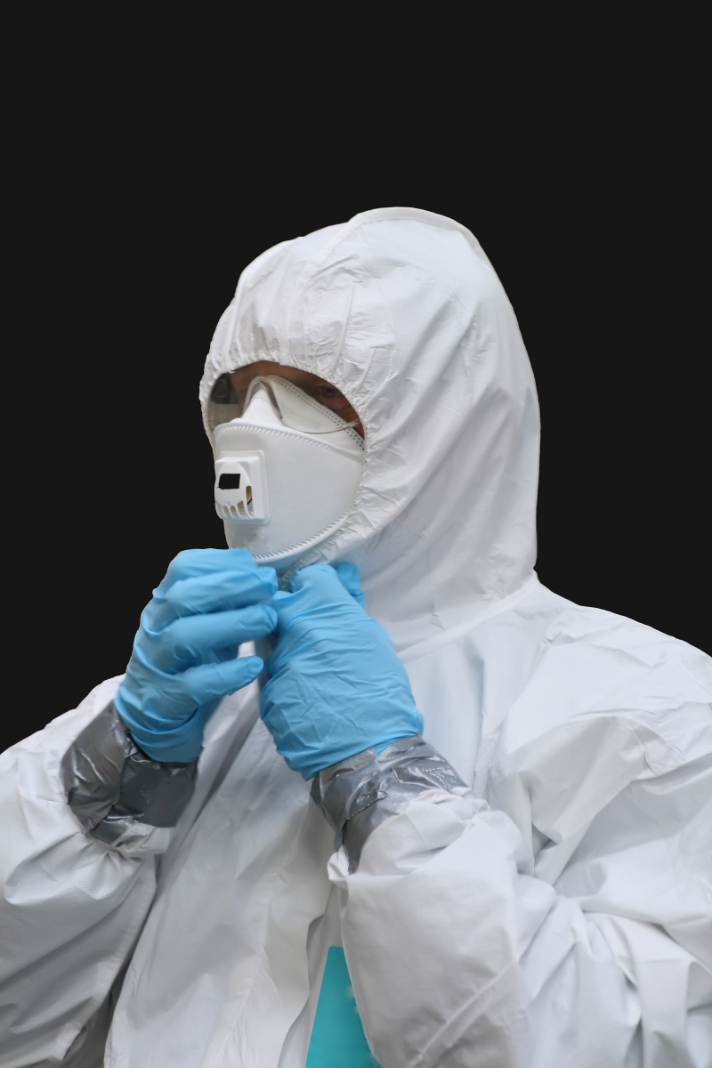Technicien en combinaison inspectant des matériaux amiantés
